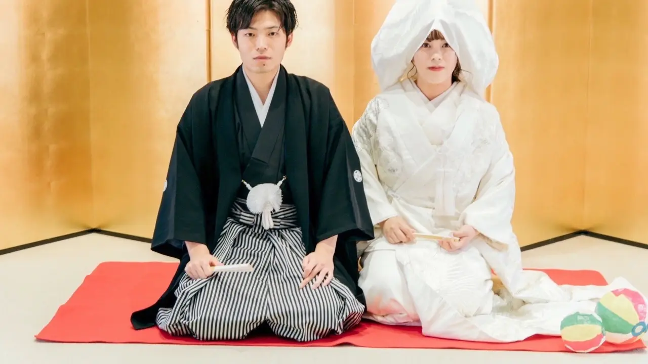 shiromuku-coordinate-07.webp01 Jolie万梨恵の着付けとヘアメイクで、金屏風の前での白無垢、綿帽子の花嫁と紋付袴の花婿の記念撮影です。