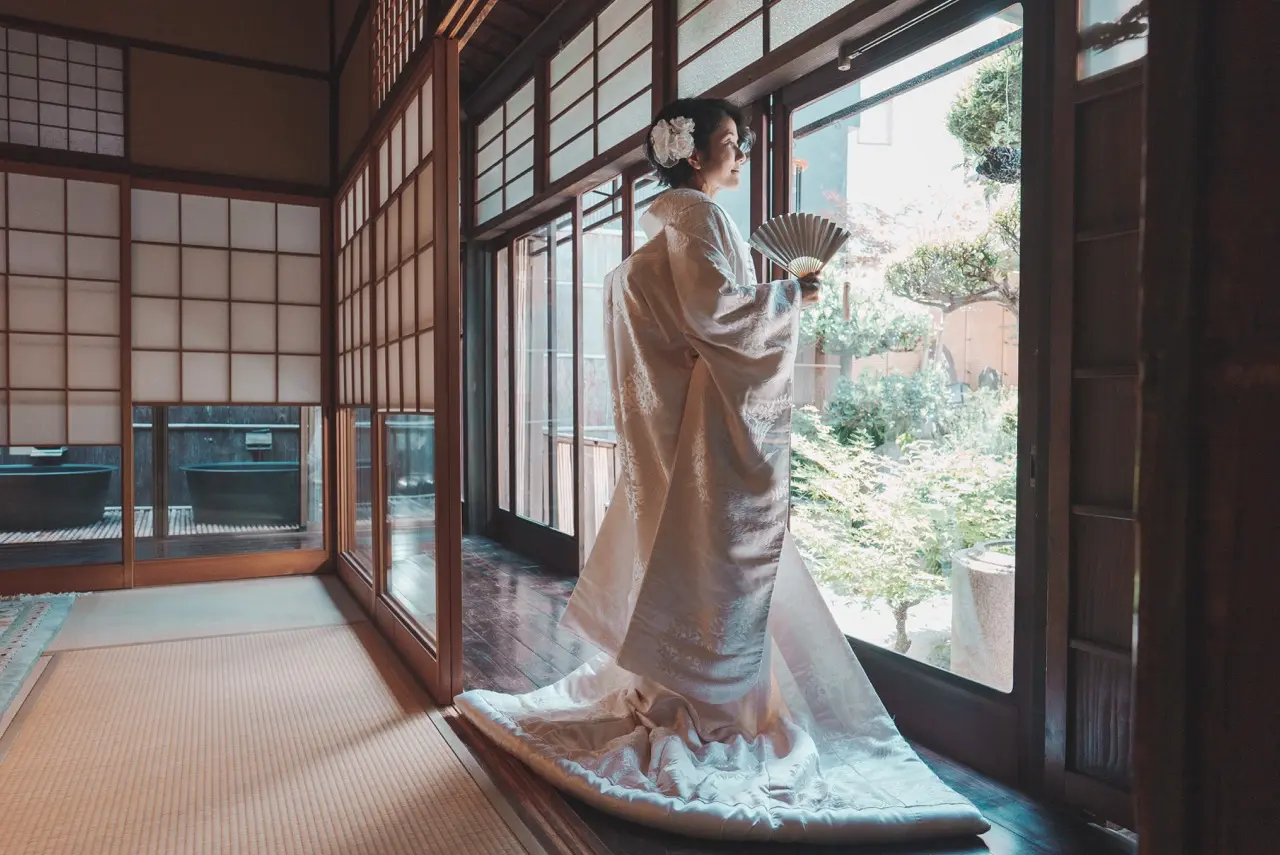 shiromuku-rental-osaka-05.webp02 日本家屋に映える白無垢、その美しいシルエット、Jolie万梨恵の着付けとヘアメイクで古民家での撮影です。