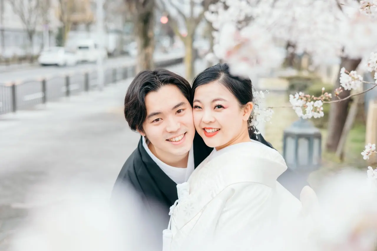 wedding-photo-wasou-10.webp04 春 満開の桜のなかで魅せる新婦。Jolie万梨恵の着付けとヘアメイクで白無垢と新郎の黒紋付姿が素敵です。